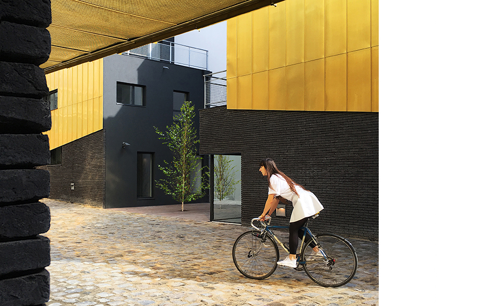 cour parisienne contemporaine, sous bassement en briques noires moulées main et étages en cuivre à joints debouts 